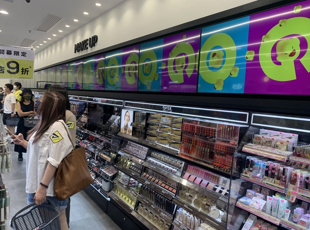 店內整牆展示了多個日本美妝品牌產品，陣容鼎盛