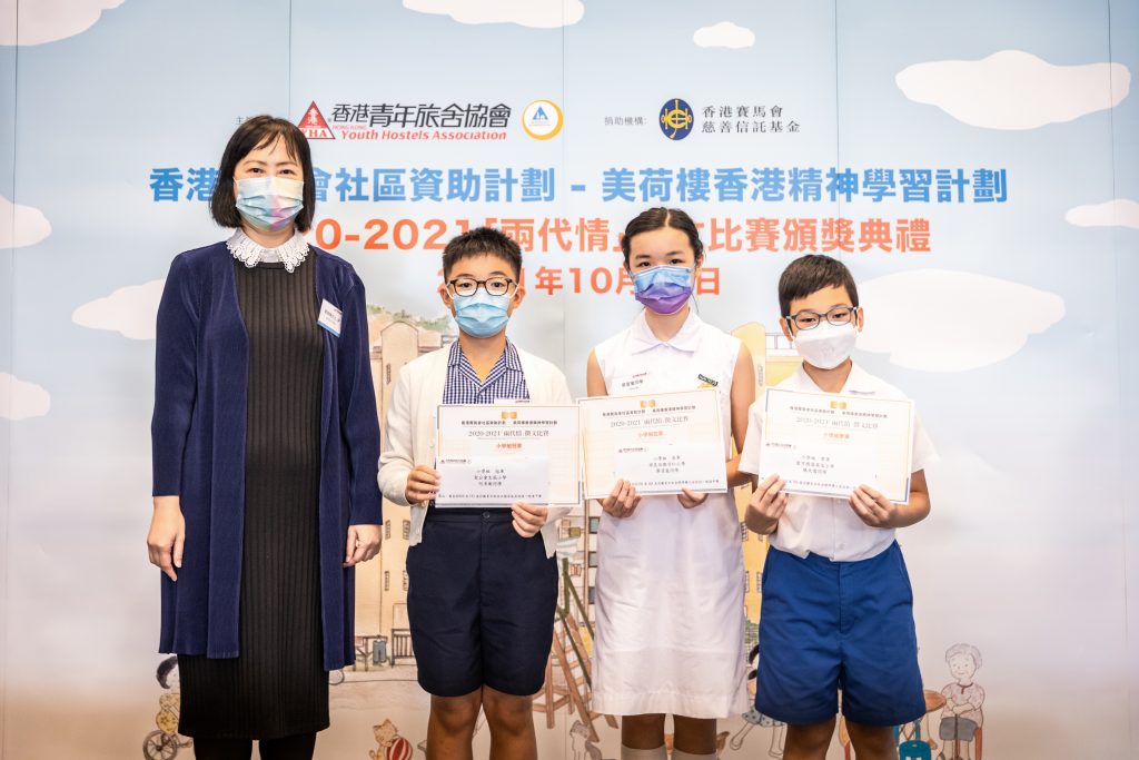 教育局常任秘書長李美嫦太平紳士頒獎予小學組三位得獎者：（左起）冠軍何卓衡、亞軍廖萱嵐，以及季軍陳天儒。
