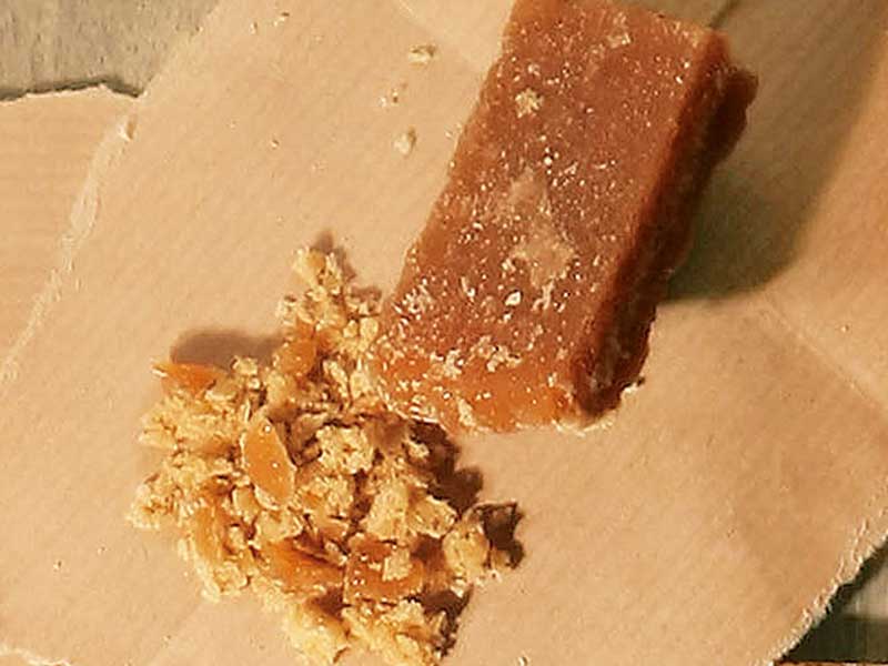 用小刀刮出片糖碎，混合植物油用來磨砂清潔
